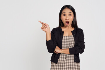 Amazed emotion young Asian woman wearing casual shirt pointing finger at copy space for text advertisement and open mouth isolated on white background. People lifestyle concept