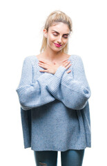 Sticker - Young beautiful blonde and blue eyes woman wearing winter sweater over isolated background smiling with hands on chest with closed eyes and grateful gesture on face. Health concept.