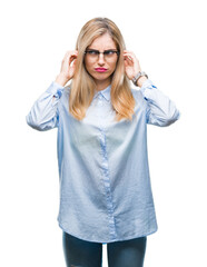 Canvas Print - Young beautiful blonde business woman wearing glasses over isolated background covering ears with fingers with annoyed expression for the noise of loud music. Deaf concept.