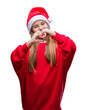 © Krakenimages.com - Young beautiful girl wearing christmas hat over isolated background smiling in love showing heart symbol and shape with hands. Romantic concept.