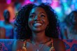 Young woman radiates joy in front of colorful neon lights, her happy face reflecting the lively energy of a festive evening out
