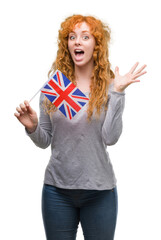 Canvas Print - Young redhead woman holding flag of United Kingdom very happy and excited, winner expression celebrating victory screaming with big smile and raised hands