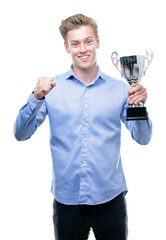 Poster - Young handsome blond man holding a trophy screaming proud and celebrating victory and success very excited, cheering emotion