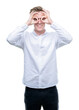 © Krakenimages.com - Young handsome blond man doing ok gesture like binoculars sticking tongue out, eyes looking through fingers. Crazy expression.