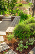 Garden path with stone slabs with bark mulch and native plants. Landscaping and gardening concept.