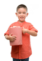 Poster - Dark haired little child eating popcorn with surprise face pointing finger to himself