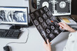 Female doctor examine an MRI image of the brain in an MRI room sitting at computer. Blurred image	