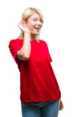 Wall Mural - Young beautiful blonde woman wearing red t-shirt over isolated background smiling with hand over ear listening an hearing to rumor or gossip. Deafness concept.
