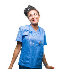 Poster - Young braided hair african american girl professional surgeon over isolated background looking away to side with smile on face, natural expression. Laughing confident.