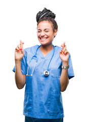 Poster - Young braided hair african american girl professional surgeon over isolated background smiling crossing fingers with hope and eyes closed. Luck and superstitious concept.