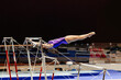 woman gymnast exercise on uneven bars gymnastics on black background