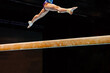 legs woman exercise split jump on balance beam gymnastics in black background