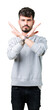 © Krakenimages.com - Young handsome man wearing sweatshirt over isolated background Rejection expression crossing arms doing negative sign, angry face