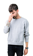Wall Mural - Young handsome man wearing sweatshirt over isolated background tired rubbing nose and eyes feeling fatigue and headache. Stress and frustration concept.