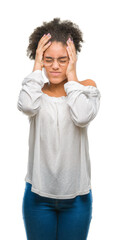 Wall Mural - Young afro american woman wearing glasses over isolated background suffering from headache desperate and stressed because pain and migraine. Hands on head.