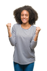 Wall Mural - Young afro american woman over isolated background celebrating surprised and amazed for success with arms raised and open eyes. Winner concept.