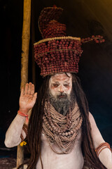 Portrait of an holy male naga sadhu baba with ash on his and long hairs wearning rudraksha necklace during the kumbh festival in India.