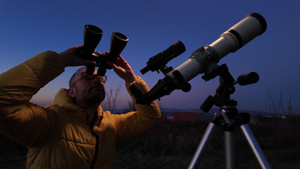 Wall Mural - amateur astronomer looking at the evening skies, observing planets, stars, moon and other celestial 
