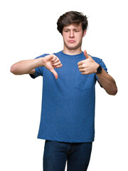 Sticker - Young handsome man wearing blue t-shirt over isolated background Doing thumbs up and down, disagreement and agreement expression. Crazy conflict