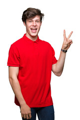 Wall Mural - Young handsome man wearing red t-shirt over isolated background smiling with happy face winking at the camera doing victory sign. Number two.