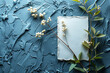Elegant blue textured background with white flowers and a blank card, perfect for invitations and elegant announcements.