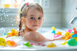 Cute little girl playing with rubber toys in bathtub. Happy kid having fun while bathing.