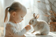 Adorable little girl playing with pet rabbit at home