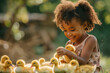 Adorable little girl playing with ducklings outdoors