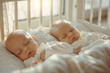 Two adorable twin babies sleeping in co-sleeper crib attached to parents' bed. Little children having a day nap in cot. Sleep training concept. Infant kids in sunny nursery.