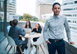 © peopleimages.com - Portrait, businessman and smile on balcony in confident or pride as designer in company with colleagues or coworkers. Male person, web developer and outdoor for meeting, networking or brainstorming