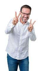 Wall Mural - Handsome middle age elegant senior business man wearing glasses over isolated background smiling looking to the camera showing fingers doing victory sign. Number two.