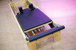 Reformer pilates stretcher. Equipment for Pilates classes. Wooden and leather pilates bed with colorful tensioners.