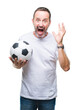 © Krakenimages.com - Middle age hoary senior man holding soccer football ball over isolated background very happy and excited, winner expression celebrating victory screaming with big smile and raised hands