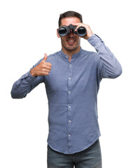 Sticker - Handsome young man looking through binoculars happy with big smile doing ok sign, thumb up with fingers, excellent sign