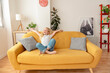 Happy female kid relaxing sitting on the sofa at home - Childhood and healthy life style concept