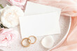 Cards near roses, wedding rings and cream fabric on plates close up, copy space, wedding mockup
