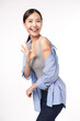 young asian women smiling after getting a vaccine, holding down her shirt sleeve and showing her arm with bandage after receiving vaccination on white background, and she shows ok sign,