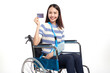 young asian women with happy smiling and show credit card sitting in a wheelchair on white background, healthcare concept, accident, insurance, life insurance, wellness, hospital.