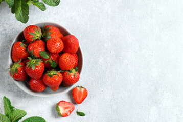 Wall Mural - organic strawberries in a bowl on a gray background