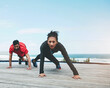 © peopleimages.com - Couple, stretching and legs for fitness outdoor with warm up, blue sky and morning activity for flexibility on floor. People, exercise and teamwork by ocean with wellness, mockup and active