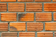 Closeup view of old grunge red brick wall background. The  old wall of grooved bricks with cement.