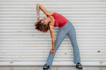 Wall Mural - young afro american woman in summer on the street with expression and posture