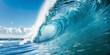 A large, powerful wave with blue water and clear sky in the background