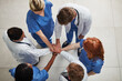 © peopleimages.com - Top view, teamwork or hands of doctors in stack with mission in collaboration for healthcare support. Hospital clinic, people or group of medical nurses with solidarity, motivation or community help