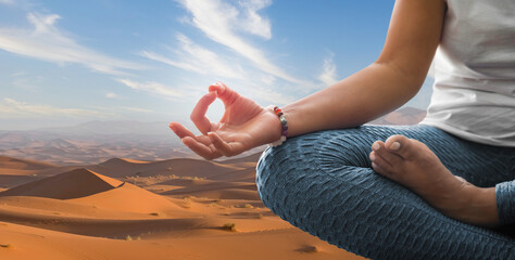 Wall Mural - Woman meditating in yoga position with desert background