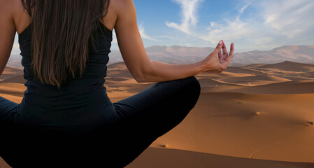 Wall Mural - Woman meditating in yoga position with desert background