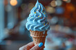 Hand Holding Blue Ice Cream Cone With Sprinkles,
Blue soft serve ice cream cone on blurred background
