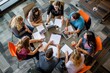 © Iftikhar alam - A group of individuals sitting around a table, focused on laptops, working and collaborating, A group of students collaborating at a round table