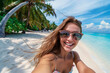 Beautiful woman in sunglasses taking selfie photo on tropical beach