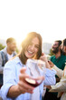 © CarlosBarquero - Vertical. Point of view of pretty young woman toasting with glass of red wine in hand smiling. Girl posing for photo at party with her friends outdoors at sunset. People gathered celebrating success.